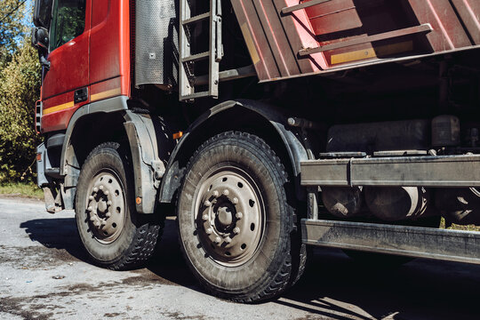 Red parked truck. Red dump truck. Industrial cargo transportation. truck wheels close up