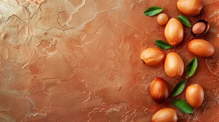 Foto op Canvas Argan nuts and leaves arranged on a textured surface, with space for text. Concept: skincare and haircare. © Anna Lurye