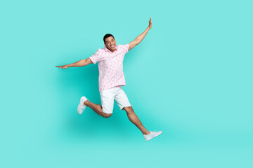 Fototapeta na wymiar Full size photo of carefree optimistic guy dressed t-shirt white shorts flying hold palms like wings isolated on teal color background