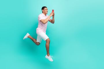 Fototapeta na wymiar Full length photo of multiethnic multinational man recording video on smartphone run in empty space isolated on turquoise color background