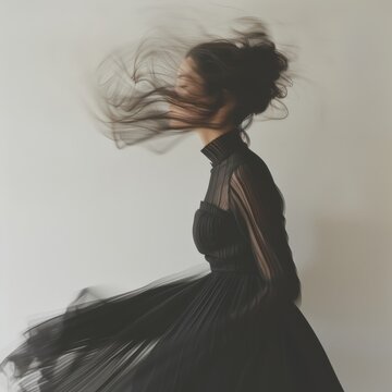 Motion blur photo of a woman in a black dress turned to a white background
