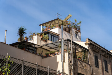 Fototapeta na wymiar A building with a rooftop garden and a balcony
