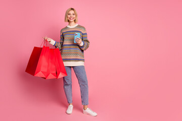 Full length photo of adorable positive woman dressed print sweater order new outfit in smartphone...