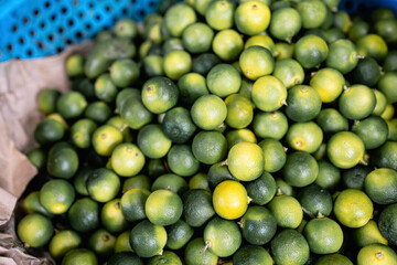 blur image of Freshly harvest Calamondin at market . selective focus, low light 