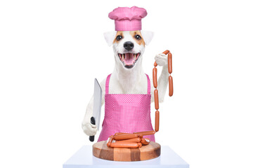 Portrait of a funny Jack Russell terrier in a kitchen apron and cap with a knife and a bunch of sausages in his hands isolated on a white background