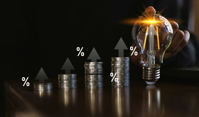 Interest rate and dividend concept.Businessmen touch the light bulb with the percentage symbol and...