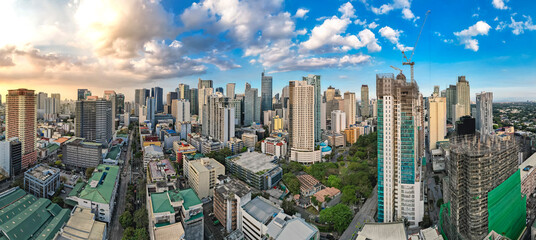 Makati, Philippines - Stunning panoramic aerial view of the bustling Makati Central Business District (CBD) skyline in the Philippines under a dramatic sky.