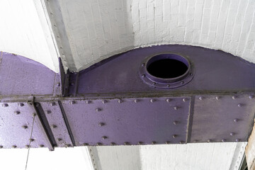 A purple metal beam with a hole in it