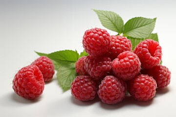 Close-up view of ripe raspberries with leaves on a neutral  background.