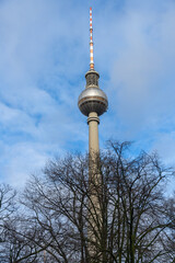 A tall tower with a red and white top is seen against a blue sky
