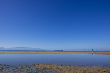 干潟の潮だまりに映る空の青