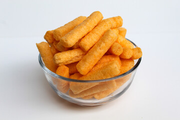 Stik Balado, crackers with savory powder coating. In transparent glass bowl. Isolated on white background
