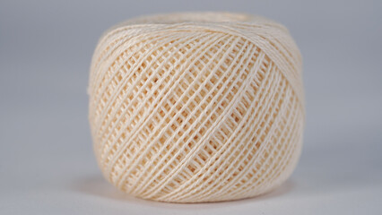 Close-up of a cream/Ivory ball knitting thread on white background.