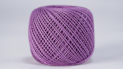 Close-up of a purple ball thread on white background.