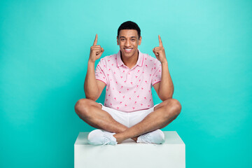 Full size photo of good mood guy dressed pink polo shorts sit on podium indicating at offer empty...