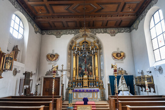 The inside of a church with a large altar and a stained glass window