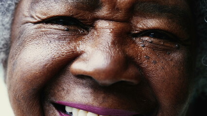 Macro close-up of a happy Senior black woman smiling at camera with wrinkled face showing wisdom...