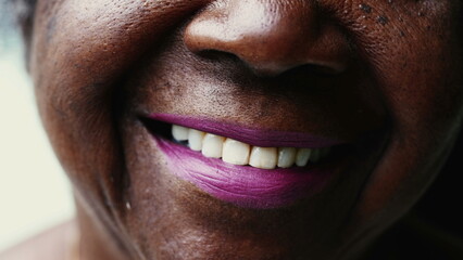 Macro close-up of a happy Senior black woman smiling at camera with wrinkled face showing wisdom and old age. Portrait of an African American lady in her 80s - obrazy, fototapety, plakaty