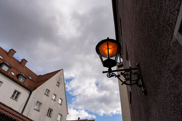 A street lamp is lit up in front of a building
