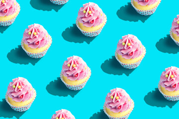 Colorful cupcake pattern on pastel blue background. Creative minimal party concept.