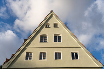 A white building with a triangular roof and many windows