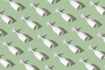 Pattern with a white champagne glass on green background. Minimal party concept.