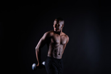 Portrait of a happy african man with dumbbells over red and black background