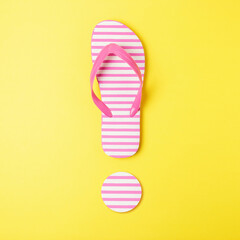 Exclamation mark made of beach slippers on yellow background. Summer minimal concept.