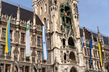 Fototapeta premium A large building with a clock tower and flags hanging from the roof