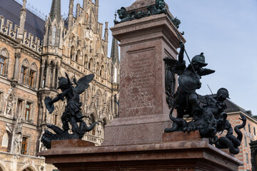Obraz premium A statue of two angels and a dragon is on top of a building