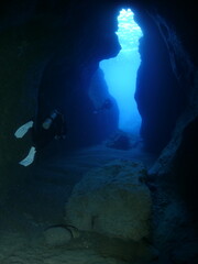 cave diving underwater scuba divers exploring caves and having fun ocean scenery sun beams and rays background