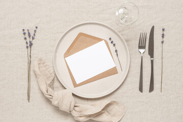 Table setting with blank card mockup and lavender on a beige linen tablecloth. Top view, flat lay. - 753075439