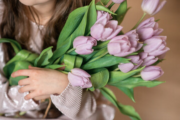 hands are holding pink  tulips 