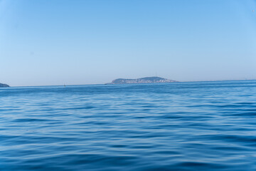 Obraz premium The ocean is calm and blue, with a small island in the distance