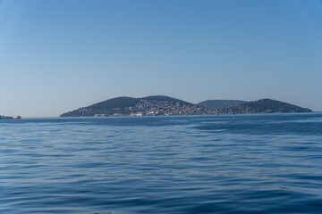 Fototapeta premium A calm blue ocean with a small island in the distance