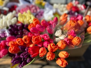 Obraz na płótnie Canvas Street sale of bouquets for International Women's Day with tulips packed before March 8 in a cardboard box . The concept of shopping for congratulations