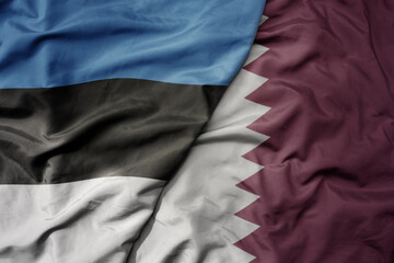 big waving national colorful flag of qatar and national flag of estonia.