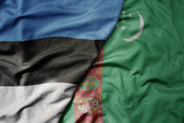 big waving national colorful flag of turkmenistan and national flag of estonia.