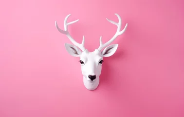 Fototapeten White Deer Head Sculpture with Antlers on a Pink Background. Christmas concept © Andrei