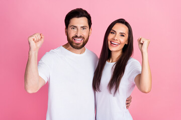 Photo portrait of attractive young couple raise fists celebrate winning dressed stylish white...