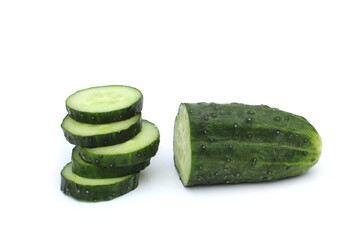 Many pieces of sliced cucumber lie on a white background.	