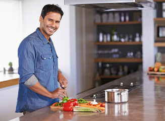 Cooking, portrait and happy man chopping vegetables on kitchen counter for healthy diet, nutrition...