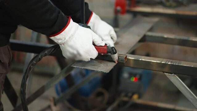 Flame and sparks in the process of metal cutting, industrial worker in protective gloves using oxy fuel torch for cutting metal plate on parts in workshop, metal industry and manufacturing concept