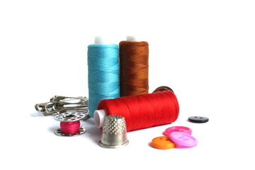 Sewing supplies lie on a white background.	