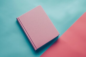 A pastel pink textured notebook on a teal and pink dual-tone background, minimalist