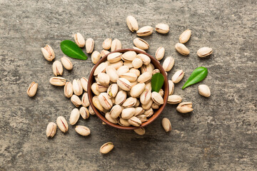 Fresh healthy Pistachios in bowl on colored table background. Top view Healthy eating concept. Super foods