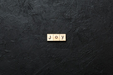 Joy word written on wood block. Joy text on cement table for your desing, concept