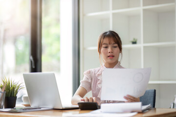 Successful Asian businesswoman dealing with business, finance, and business calculations in the office