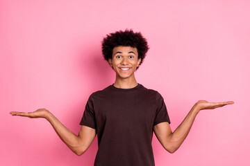 Photo of optimistic man in stylish brown t shirt choose alternatives compare same price products isolated on pink color background - obrazy, fototapety, plakaty