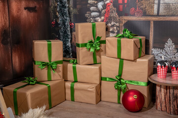 Christmas gifts in room at night. Gifts in paper wrap with green ribbon